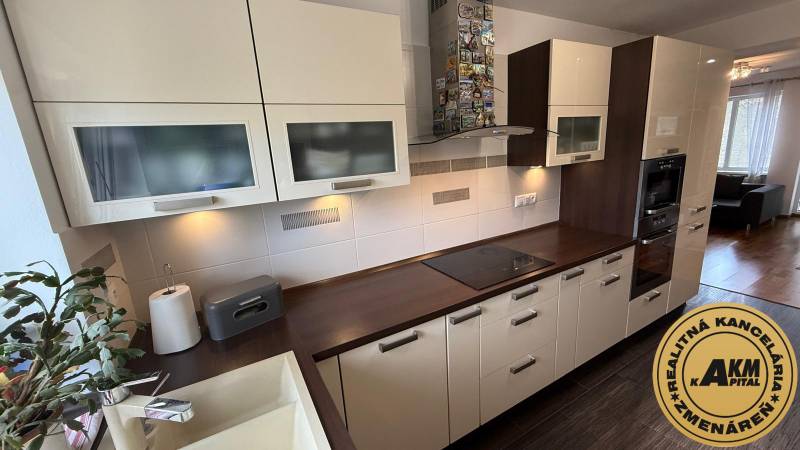 A kitchen in a 2-room apartment with white cabinets and a wood-patterned floor.