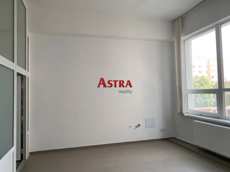 Interior office with large windows and light walls.