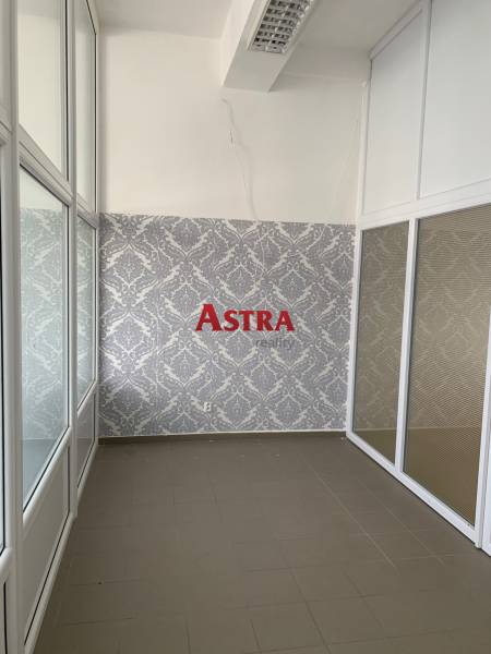 Offices with decorative wallpaper and glass partitions, tiled flooring.