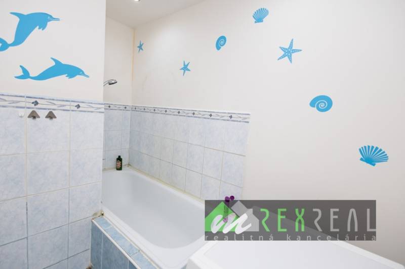 A bathroom with a bathtub and sea motifs in a 3-room apartment.