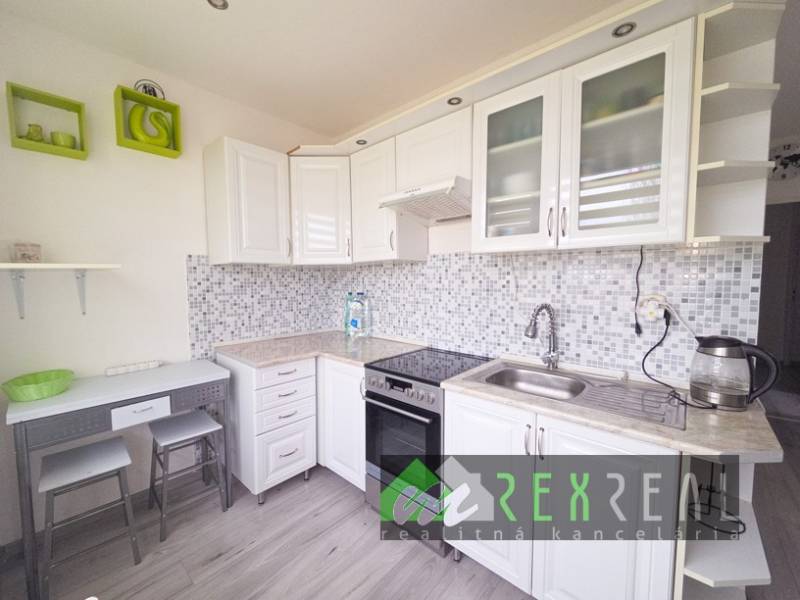 A kitchen in a 3-room apartment with mosaic tiles and a floor with a wooden decor.