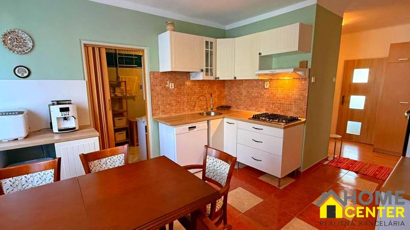 Kitchen in a 3-room apartment with a gas stove and a dining table.