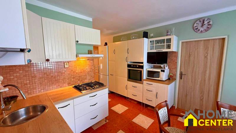 A kitchen in a 3-room apartment with a stove, sink, and cabinets for storage.