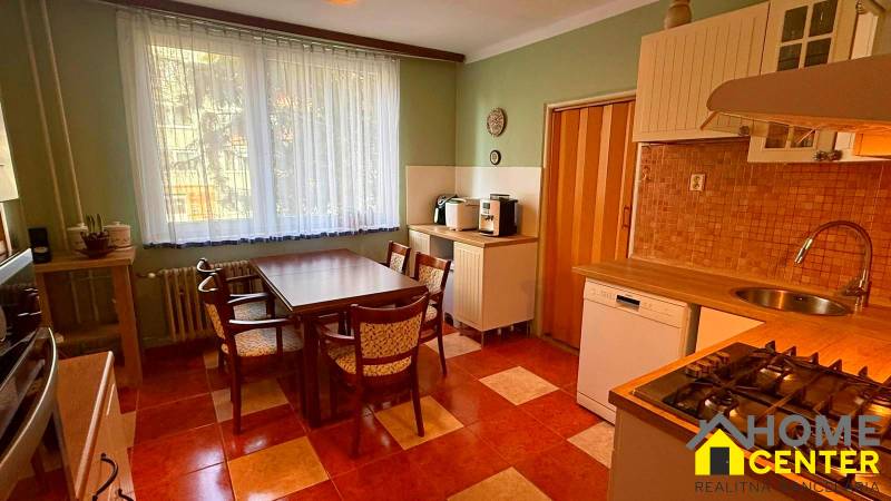 A kitchen in a 3-room apartment with seating area and appliances.