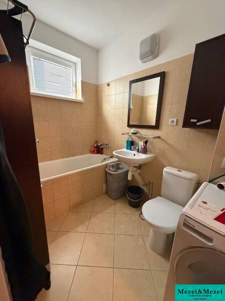 Bathroom with a bathtub, washing machine, and mirror in a 2-room apartment.