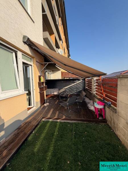 Terrace of a 2-room apartment in Most pri Bratislave with a view of the garden and seating area.