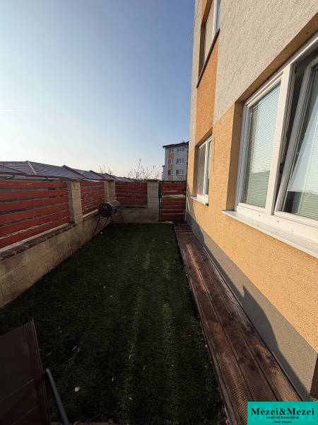 A garden by a 2-room apartment in Most pri Bratislave with wooden elements and a lawn.