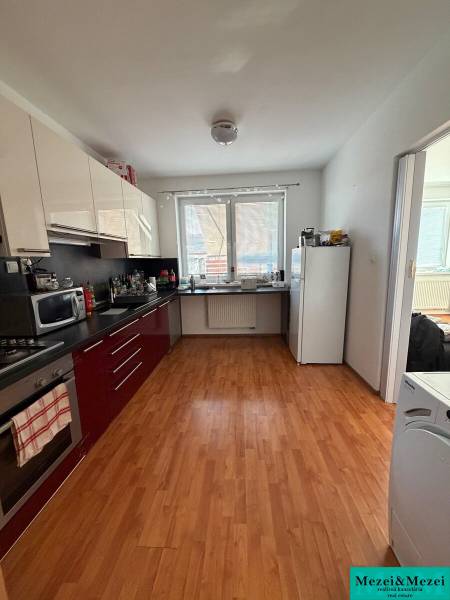 Kitchen in a 2-room apartment with a wooden decor floor and white walls.
