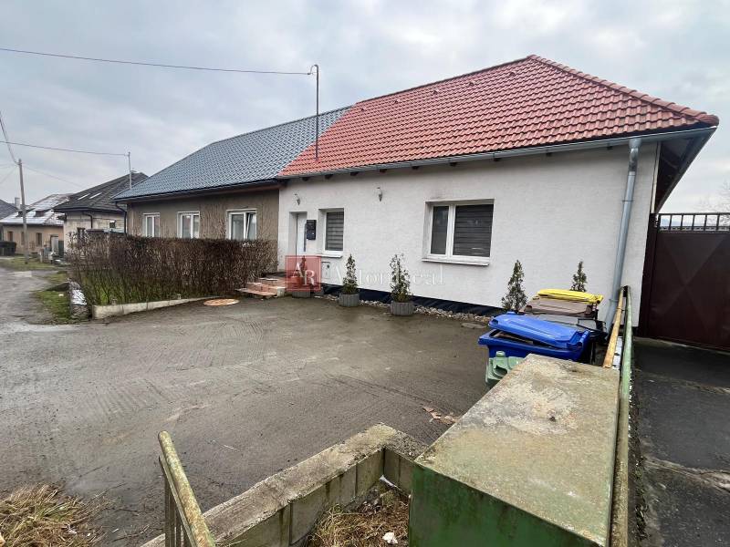 A family house on Osloboditeľov Street in Lieskovec with two colored roofs and containers.