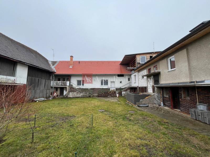 A family house on Osloboditeľov Street in Lieskovec with a grassy yard and farm buildings.