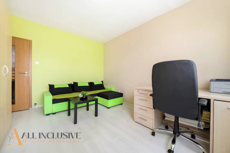 A stylish room in a 3-room apartment with a colorful sofa, table, and workspace.