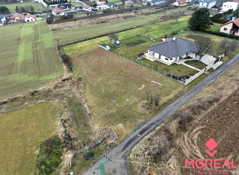 A residential plot in Kuzmice, a quiet street with a rural character and surrounding houses.