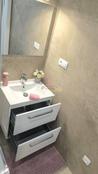 Bathroom with a mirror, sink, and cabinets in a 4-room apartment.
