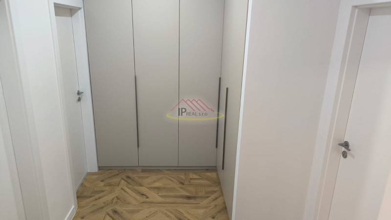 A hallway with a built-in wardrobe and a floor with a wooden decor in a 4-room apartment.