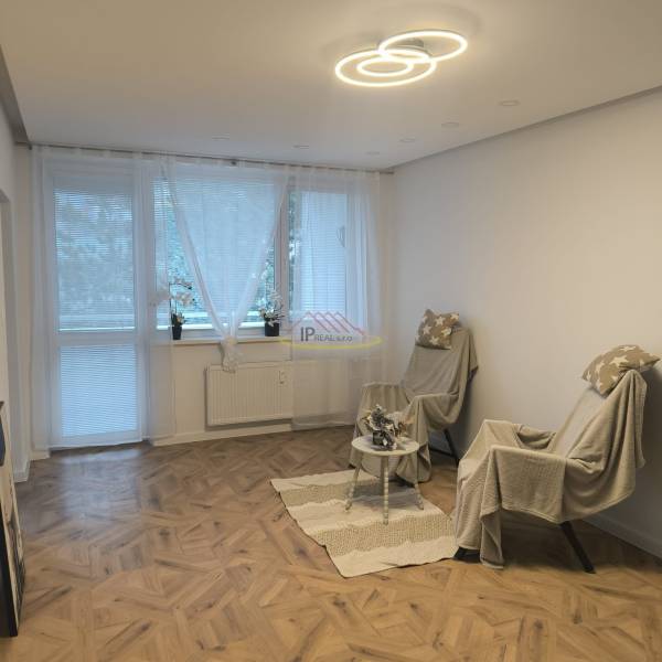 Living room in a 4-room apartment with a wooden decor floor and two armchairs.