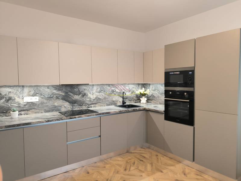 A kitchen in a 4-room apartment with marble tiles and a wooden decor floor.