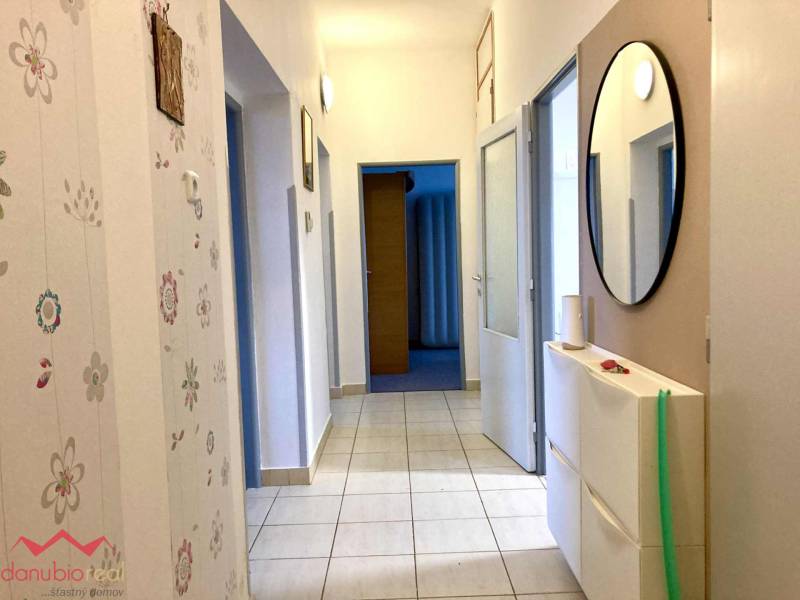 A hallway in a 3-room apartment with floral wallpaper and a mirror on the wall.
