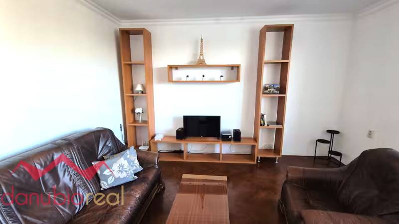 Living room in a 3-room apartment with brown furnishings and Eiffel Tower decor.
