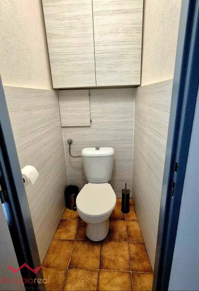 Bathroom with toilet in a 3-room apartment, tiles and practical storage cabinets.