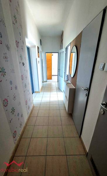 A hallway in a 3-room apartment with a tiled floor, a mirror, and patterned wallpaper.