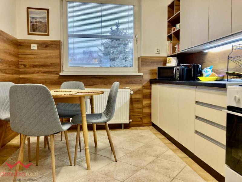 A kitchen in a 3-room apartment with a dining table, chairs, and a kitchen unit.