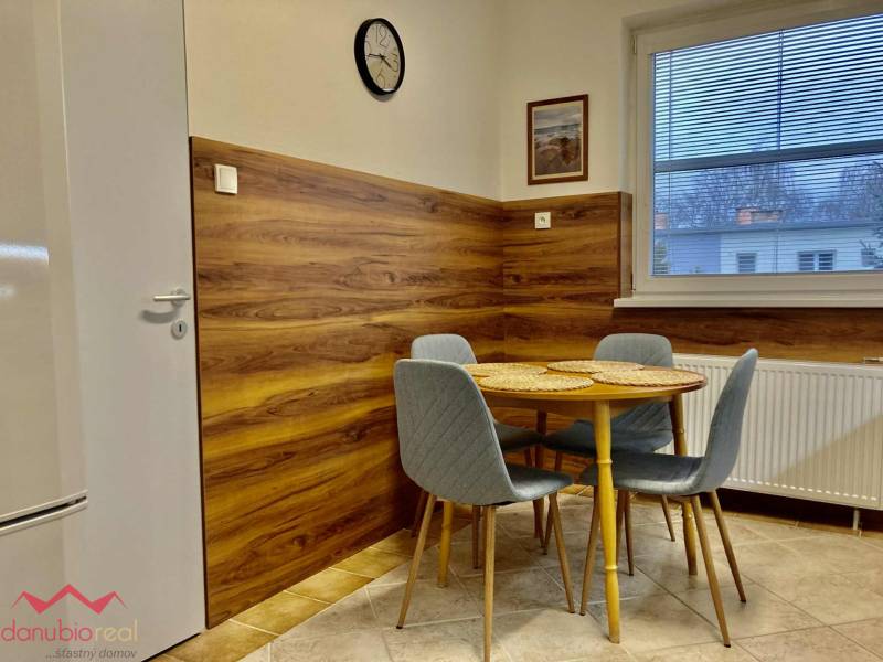 Kitchen with dining table, gray chairs, wooden decor flooring, 3-room apartment.