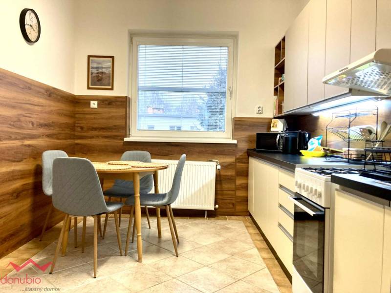 A kitchen in a 3-room apartment with a dining table, floor with wood decor.