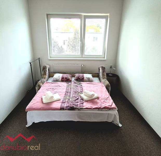Bedroom in a 3-room apartment with a bed, a window, and towels placed on the decor.