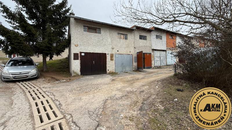 Garages on Prachatická Street in Zvolen with the real estate agency's sign.