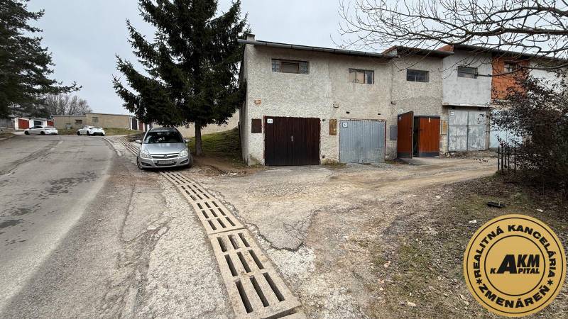 Garages on Prachatická Street in Zvolen with parked cars and trees.