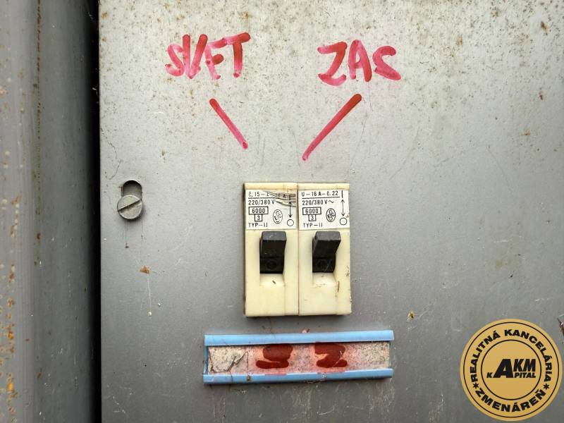 Circuit breakers with handwritten labels on a metal surface in the garage.