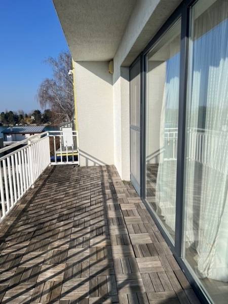 The balcony of the cottage at Slnečné jazerá in Senec with a floor featuring a wooden decor.