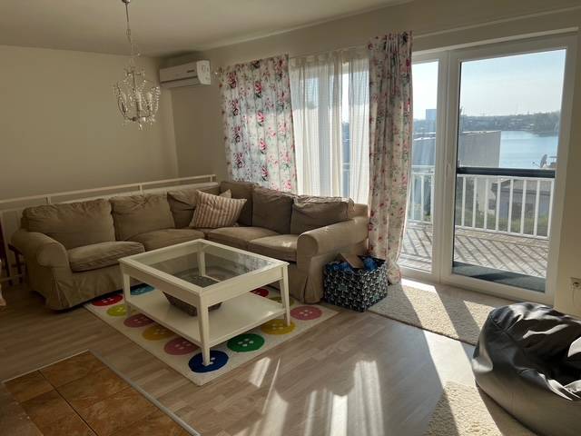 Living room with a sofa, coffee table, and floral curtains in a cottage.