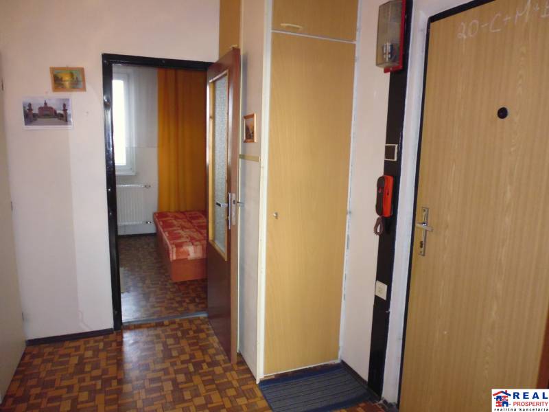 Interior of a 1-bedroom apartment with a wooden decor floor and simple furnishings.