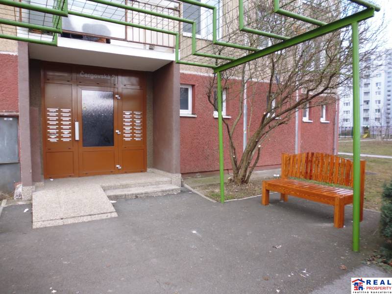 Entrance on Čergovská Street with a bench, ideal for a 2-room apartment in a panel building.