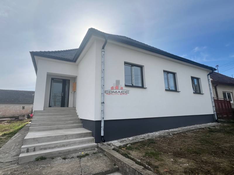 A family house in Sasinkovo on Sasinkovo Street with a white facade and a staircase.