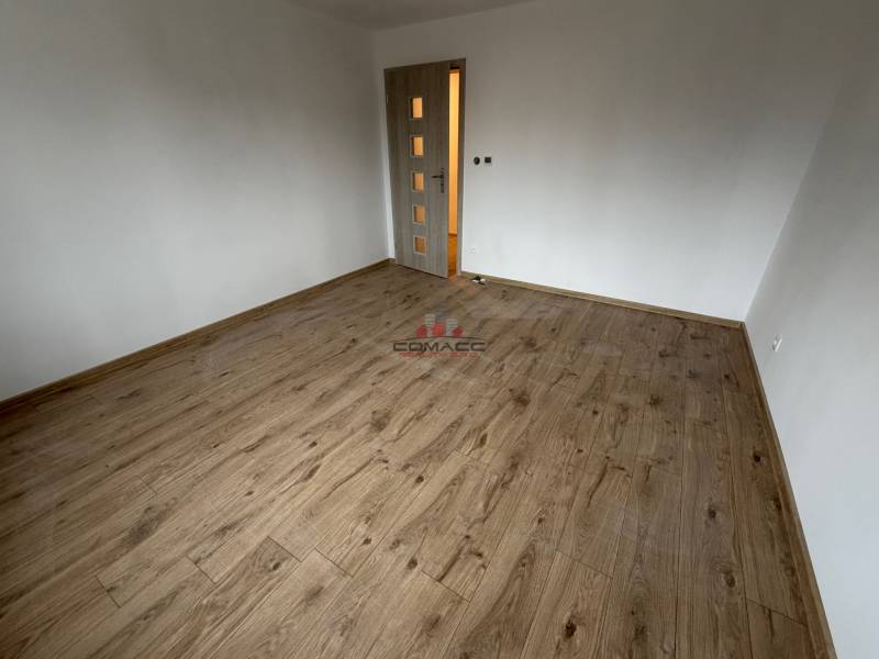 A room in a family house with a wooden floor decor and light-colored walls.