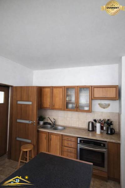 A kitchen in a family house with wooden cabinets and a countertop.