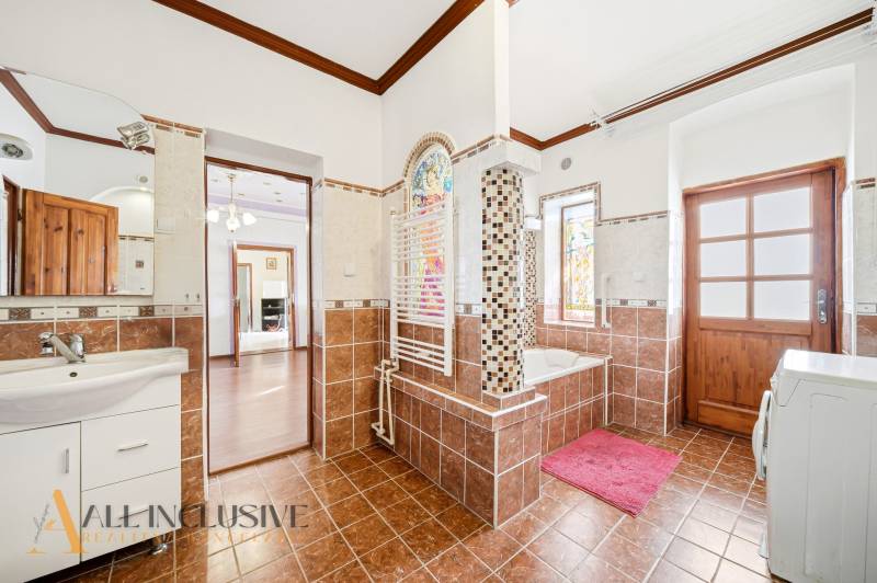 Bathroom with colorful tiles and wooden decor flooring.