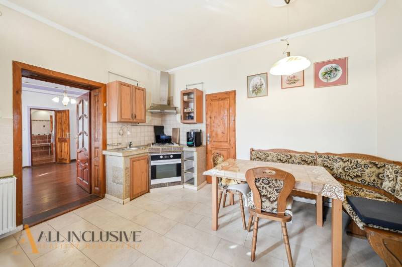 A kitchen with built-in appliances and a dining table in the interior of residential plots.