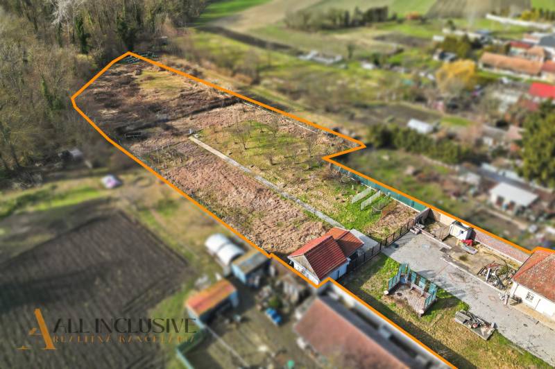 A plot of land in the village of Vrakúň for residential purposes, with fruit trees and buildings in the corner.