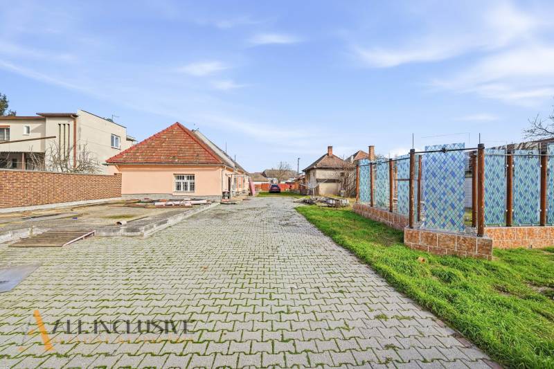 Paved access road leads to houses, plots - housing in Vrakúň.