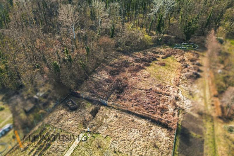 An aerial view of overgrown residential plots in Vrakúňa, bordered by forest.
