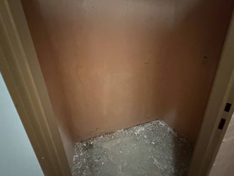 A small empty space with bare walls and a raw floor in a 3-room apartment.