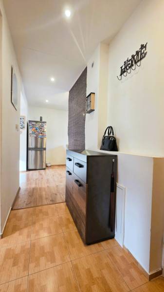 A hallway with a chest of drawers, a wooden decor floor, opens up the space in a 2-room apartment.