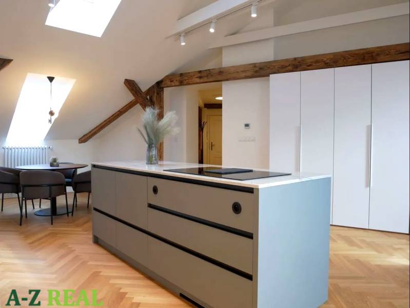 The kitchen in the 3-room apartment features a cooking island, a floor with a wooden decor, and a dining table.