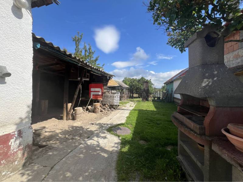 A family house in Dolné Orešany with an outdoor seating area and a garden fireplace.