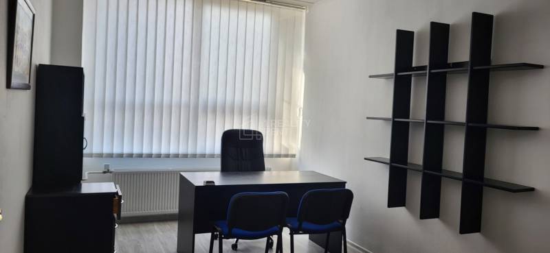 Offices with furniture, a window with vertical blinds, and a floor with a wood decor.