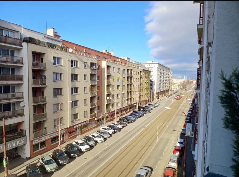 A view of a city street in Bratislava - Old Town with tram tracks and parked cars.