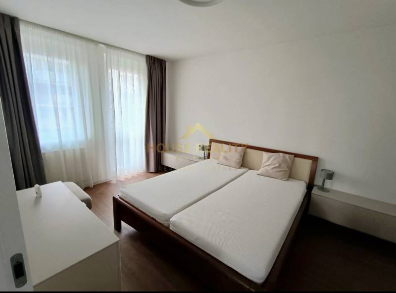Bedroom in a 2-room apartment with a bed and a wooden decor floor.